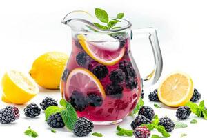 A pitcher of blackberry lemonade with a few slices of lemon and blackberries. The pitcher is full and the fruit is visible photo
