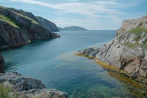 A tranquil coastal inlet, with calm waters and rocky cliffs photo