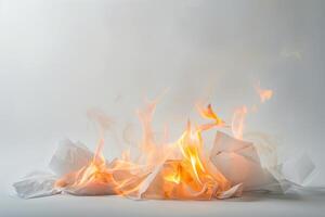Burning paper engulfed in flames against a soft transparent white background, symbolizing destruction and transformation photo