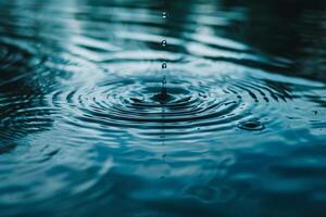 Gentle raindrops falling onto a calm body of water, creating ripples on the surface photo
