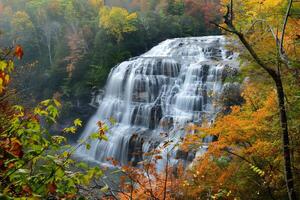 Cascading waterfall framed by vibrant autumn foliage photo
