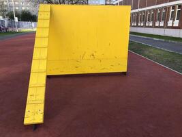ladder to the yellow high wall of a gymnastics obstacle course photo