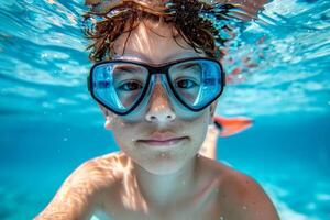 A young boy is swimming in a pool wearing goggles. photo