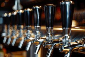 Closeup of beer tap handles lines in a bar against a dark background photo