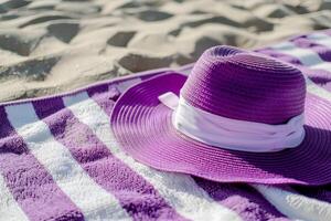 Purple and White Striped Hat on Beach Towel by the Seashore. summer vocation concept photo