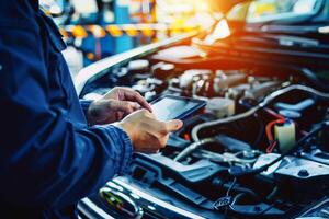 Male Mechanic Uses a Tablet Computer with an Augmented Reality Diagnostics Software. Specialist Inspecting Car. . photo