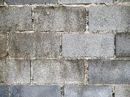 A white wall with a hole in it. The wall is cracked and has a rough texture photo