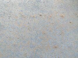 A white wall with a hole in it. The wall is cracked and has a rough texture photo