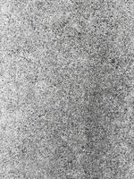 A white wall with a hole in it. The wall is cracked and has a rough texture photo