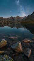 Pristine alpine tarns reflecting starry night skies photo