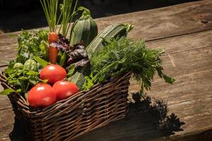 Local grown, farm vegetables in a basket on a wooden brown table photo