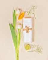 Relax, spa composition with white towel, tulips and citrus fruits on light background photo