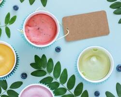 Different types of vegan, fruit ice cream on a blue background with empty label photo