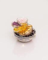 Different kind of vitamins in glass bowls with lighting garland on a white background with reflection photo