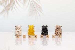 Diferent kind of vitamins in a glass jar on a white table photo