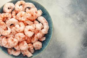 Close up frozen pilled shrimps with ice cubes photo