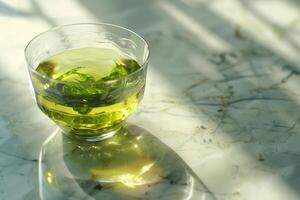 A cup of Green Tea on a marble countertop photo