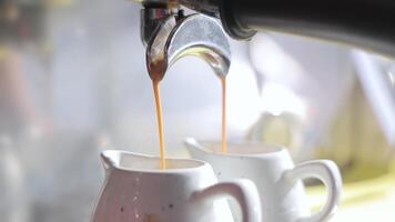 Preparation of double coffee in white cups close-up. Making espresso in a cafe video