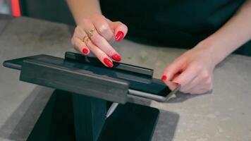 Close-up of female hands pressing cash register buttons, counting and calculating transactions. Small family business concept video