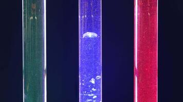 Experimental flasks are filled with green, blue and red matter with tiny bubbles. Oxygen bubbles rise up in the flask. video