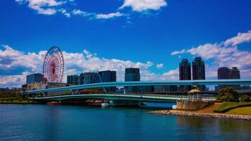 A timelapse of ferris wheel at the amusement park in Odaiba Tokyo daytime wide shot video