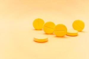 Yellow pills on a yellow background. Focus on foreground, soft bokeh. photo