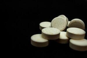 Pills on a black background. Focus on foreground, soft bokeh. photo