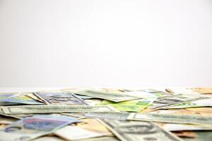 A close-up image of a messy pile of US Dollar and Euro banknotes scattered across a plain white surface photo