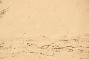 A close-up image of tan sand with visible cracks photo