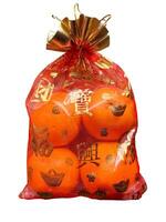 Oranges in a Chinese cloth bag isolated on white background. Oranges are auspicious fruits according to Chinese beliefs because their skin color is like gold. And in Chinese it also means happiness. photo
