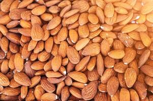background with orange peeled almond kernels on market counter close-up photo