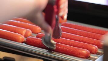 Hot Dog Sausages, Heated And Rotated. Close-up Of A Cook's Hand Taking A Sausage With Tongs. video