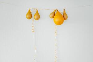 Deflated balloons on golden string white background photo