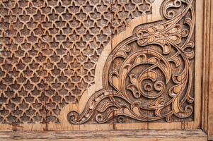 ancient east pattern Uzbek traditional ornament on wooden carved door in Tashkent in Uzbekistan photo