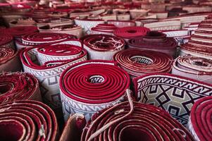 stack of rolled up oriental red carpets for Muslim prayer in Tashkent in Uzbekistan photo