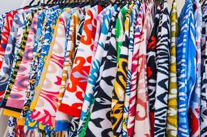 Asian dresses made of silk fabric with bright colorful pattern at oriental bazaar in India close-up photo