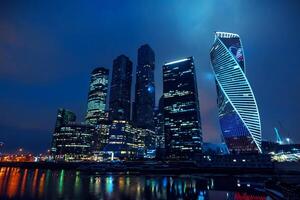 High modern skyscrapers of Moscow city with lighting and reflection in the river photo