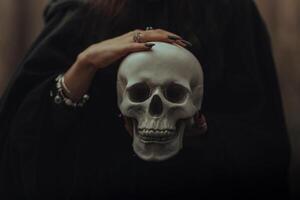 skull of a dead man in the hands of a witch witch photo