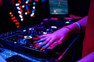hand of a DJ girl on the background of a music controller mixer photo