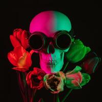 human skull in steampunk glasses in tulip flowers with colored neon light photo