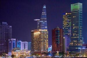 Ho Chi Minh City skyline and the Saigon River. Amazing colorful night view of skyscraper and other modern buildings at downtown. Travel concept photo