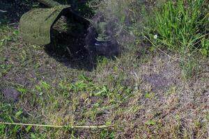 A man cuts and mows the grass. Grass cutting work. Worker mows lawn with grass photo