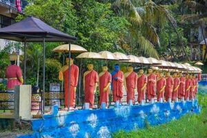 row of Buddhist monk statues in Dambulla photo