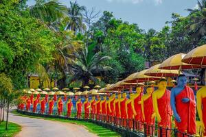 row of Buddhist monk statues in Dambulla photo