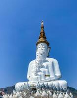 The big white Buddha five statue,Phetchabun is one of the top Thailand famous temples with a huge five white jade buddhas layered statue,Wat Phra That Pha Kaew, Phetchabun,Five white Buddha statue. photo