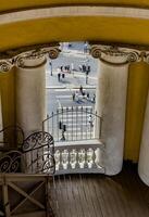Overhead view of pedestrians crossing the street as seen from a balcony with classical columns in Saint Petersburg. Ideal for travel, architecture, and urban photography themes. photo