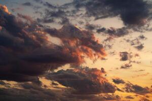 A stunning display of dramatic clouds illuminated by the vibrant colors of a sunset, showcasing the beauty and complexity of nature's evening skies. Perfect for backgrounds and atmospheric scenes. photo