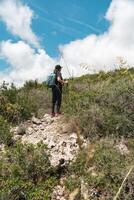 Woman takes a break while climbing the mountain, while taking a breath to continue her path. photo