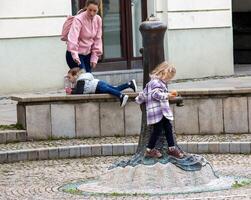 Nitra, Slovakia - 05.15.2023 Children play with an old water pump in the old town photo