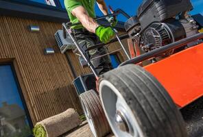 Gardener Aerating Soil in Front of House photo